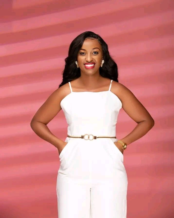 Monica Chege standing confidently in a white outfit